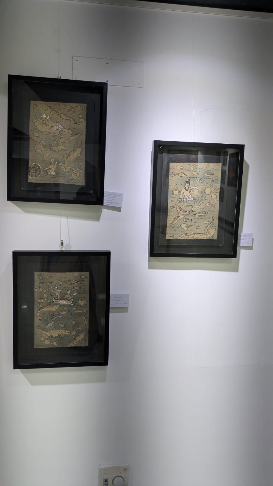 Three framed artworks on a white wall