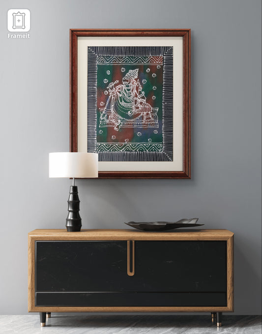 Framed artwork above a wooden cabinet with a lamp and decorative plate on a gray wall.